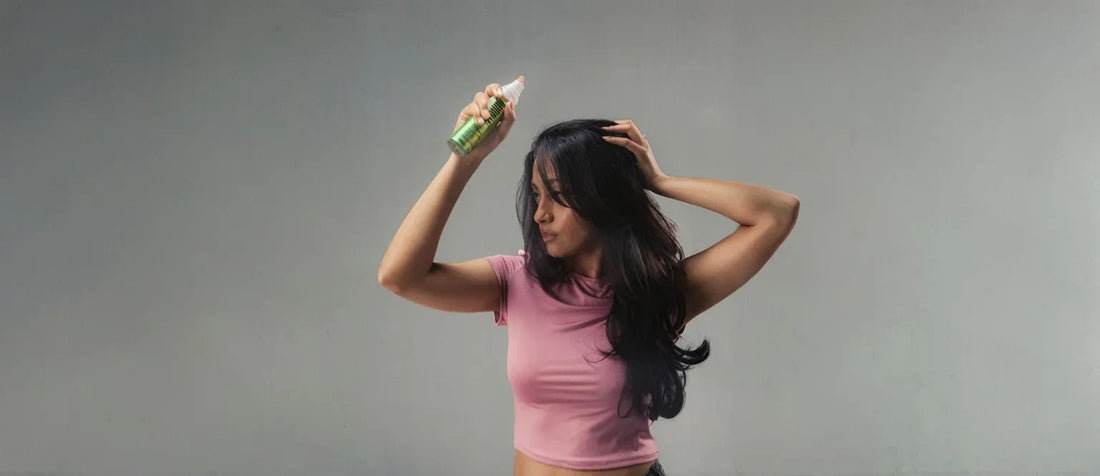 A woman with fine hair using a volumizing spray to effortlessly add volume and texture to her hairstyle.