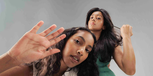 A woman applying natural hair oil to reduce hair fall effectively, showcasing healthy hair care practices.