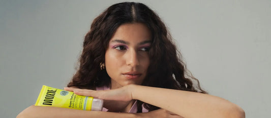 A person applying natural oil to their scalp, promoting hairline growth and healthy hair restoration.