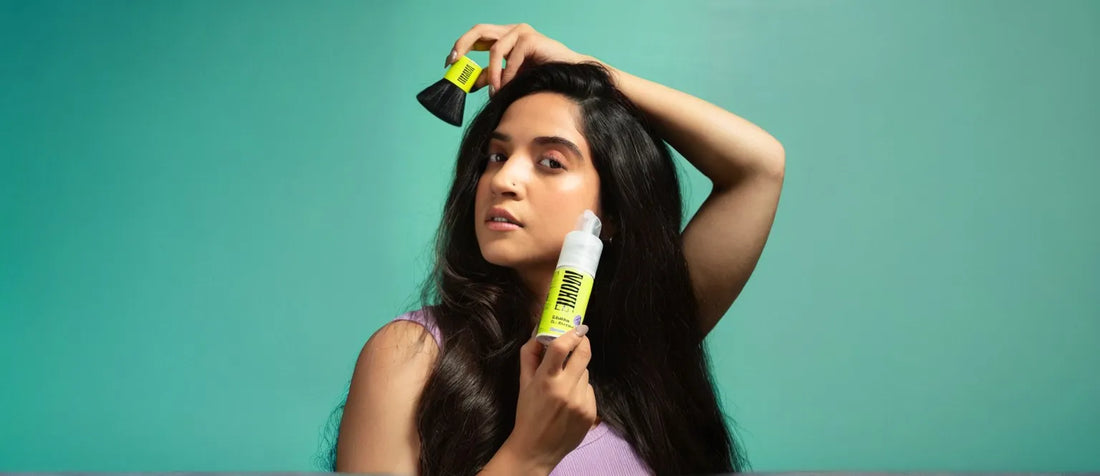 A person applying dry shampoo to manage oily hair effectively, showcasing a solution for greasy hair issues.