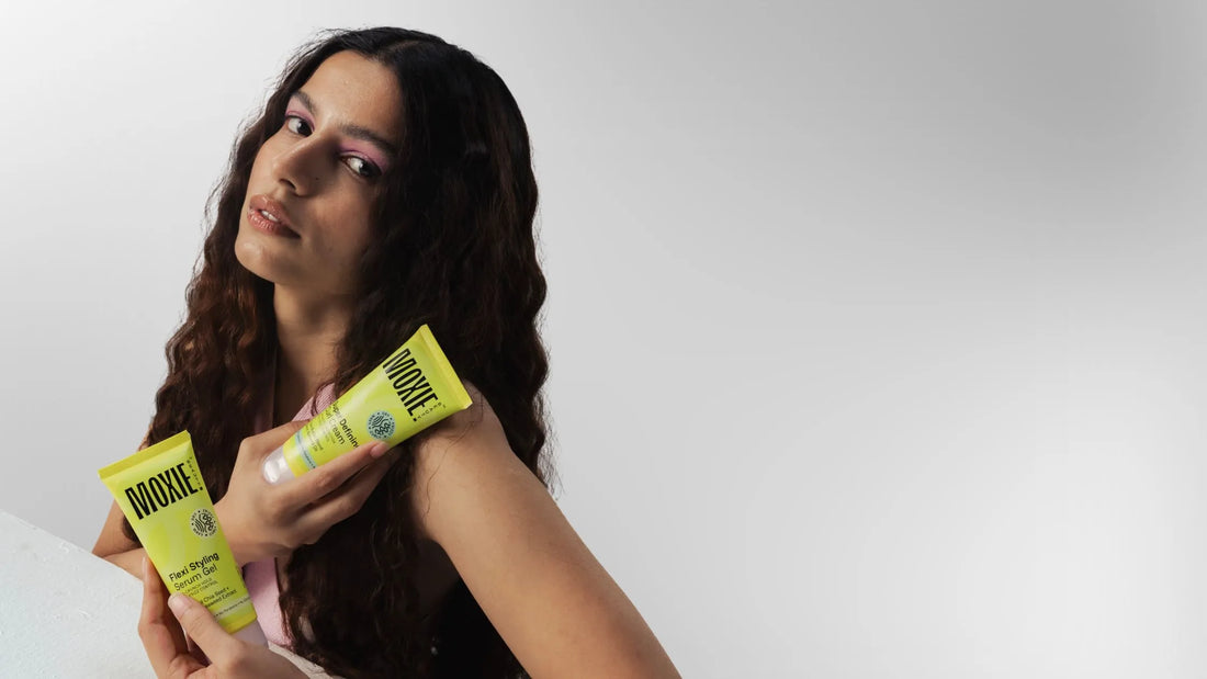 A woman with beautiful curly hair applying hair care products in her routine for healthy curls.