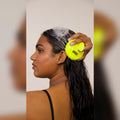 
Woman massaging her shampooed scalp with the Moxie Scalp Massager