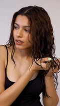 Girl scrunching her wavy hair while applying Moxie Flexi Styling Gel